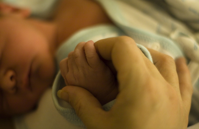 Holding hands with newborn baby