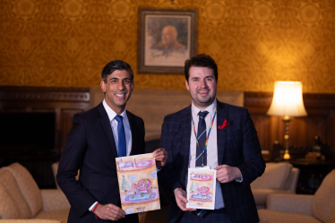 Picture of Elliot and Rishi Sunak holding the winning Christmas card design
