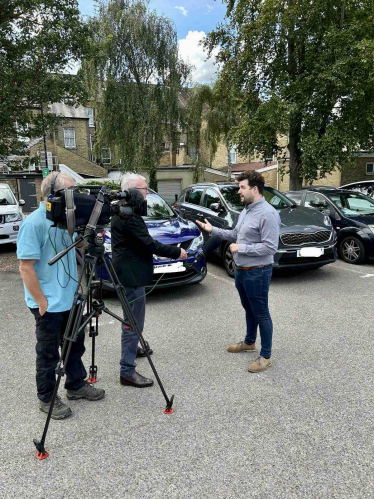 Elliot speaking to members of the press about his campaign calling on the Council to reverse its decision on parking charges.